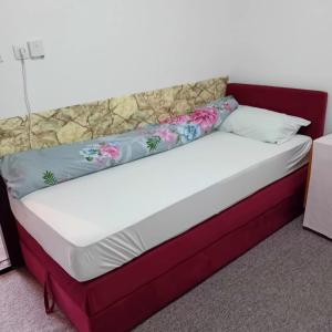 a bed in a room with a red frame and pillows at Kuca za prespavati in Bihać