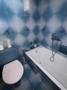a blue tiled bathroom with a toilet and a tub at Village Memories in Koronópoulon +22 photos