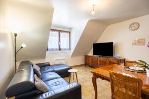 a living room with a leather couch and a table at Gîte Le Lot in Espalion