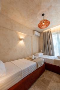 a bedroom with two beds and a chandelier at Terra Elea Luxury Pool Suite Aura in Nikiti +46 photos