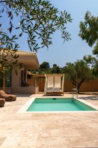 a swimming pool with a chair next to a house at Terra Elea Luxury Pool Suite Aura in Nikiti