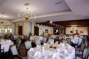 un salón de banquetes con mesas y sillas blancas en Hotel Im Engel, en Warendorf