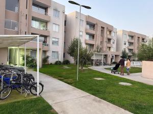 a man riding a skateboard down a sidewalk next to buildings at Departamento Amplio y tranquilo in Talca