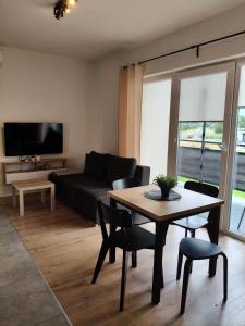 a living room with a table and a couch at Apartamenty na Ceglanej in Oświęcim