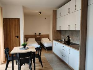 a kitchen with a table and a dining room at Apartamenty na Ceglanej in Oświęcim