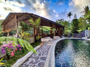 a house with a swimming pool in front of a house at Goa Walet Cottage in Praya