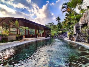 a swimming pool in front of a house at Goa Walet Cottage in Praya
