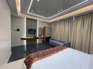 a bedroom with a bed and a desk and a couch at Hotel Vishwaraj Residency in Solapur