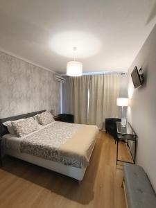 a bedroom with a bed and a chair and a table at Residencial Do Rita em Rio Caldo in Geres