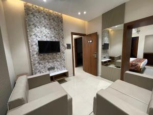 a living room with a couch and a television on a wall at Hotel Vishwaraj Residency in Solapur