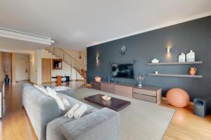 a living room with a couch and a tv at Villa Minimalista in Caniço