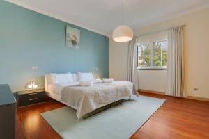 a bedroom with a large bed and a window at Villa Minimalista in Caniço +46 photos