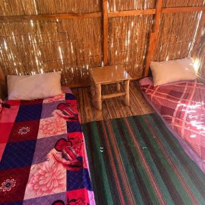 a small room with two beds and a table at La Basha Camp in Dahab