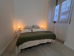 a bedroom with a large bed with two lamps on it at Alessandra guest house in Alghero