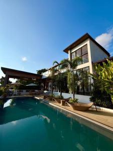 a house with a swimming pool in front of a house at Ahana Resort El Nido in El Nido