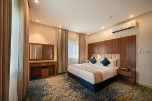 a hotel room with a bed and a television at القصر الإسكان in Khamis Mushayt