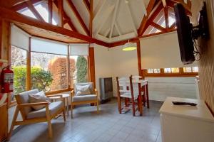 a living room with a dining room table and chairs at Los Techos Apart in Esquel