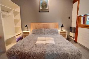 a bedroom with a large bed with two towels on it at Los Techos Apart in Esquel +22 photos