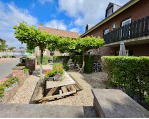a bench and a tree in front of a building at Schuttershuuske in Margraten