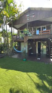 a house with a hammock in front of a yard at Recanto do Sol II in Ilha do Mel