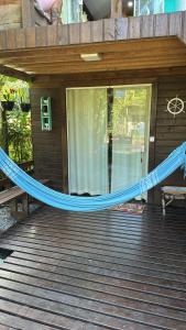 a blue hammock on the front of a house at Recanto do Sol II in Ilha do Mel