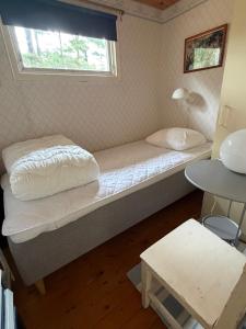 a bed in a room with a window at Havsnära fritidshus in Åhus
