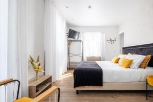 a bedroom with a large bed with yellow pillows at Alojamento Local Vitoria in Batalha