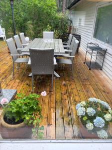 a wooden deck with a table and chairs and flowers at Havsnära fritidshus in Åhus +9 photos