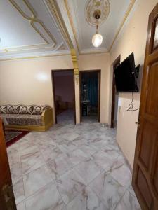 a living room with a couch and a flat screen tv at Samadis Home 3 in Larache
