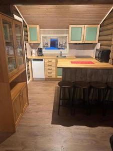 a kitchen with a counter and stools in a room at Øse Camping in Gratangen