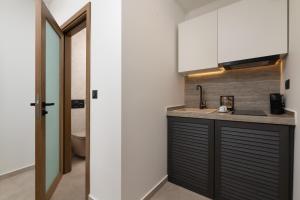 a kitchen with a sink and a counter top at Karavel Suites - Old Town Boutique Rooms in Rhodes Town