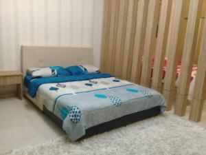 a bedroom with a bed with blue sheets and a crib at Homestay KBCC in Kota Bharu