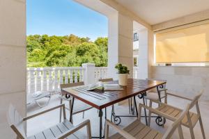 a dining room with a table and chairs on a balcony at Apartments Grifone Lux in Herceg-Novi