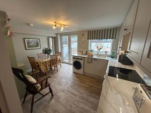 a kitchen and living room with a table and chairs at Owl Cottage - sleeps 5 near Brecon Beacons, Zip World, Bike Park Wales in Llwydcoed Station