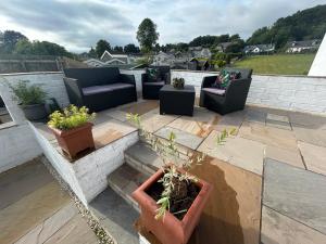 a patio with couches and potted plants on a roof at Owl Cottage - sleeps 5 near Brecon Beacons, Zip World, Bike Park Wales in Llwydcoed Station