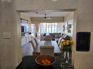a kitchen and living room with a table and a dining room at On The Beach Scottburgh in Scottburgh