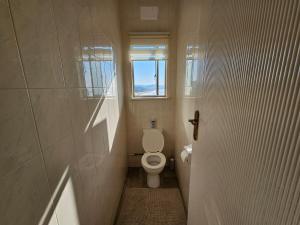 a small bathroom with a toilet and a window at On The Beach Scottburgh in Scottburgh +13 photos