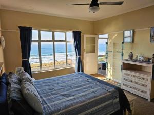 a bedroom with a bed with a view of the ocean at On The Beach Scottburgh in Scottburgh