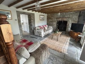 a living room with a couch and a fireplace at Owl Cottage - sleeps 5 near Brecon Beacons, Zip World, Bike Park Wales in Llwydcoed Station