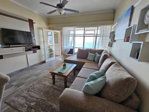 a living room with a couch and a table at On The Beach Scottburgh in Scottburgh