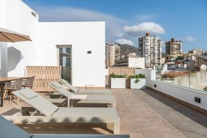 a balcony with tables and chairs and a view of a city at Cauce 4 Apartments in Torremolinos