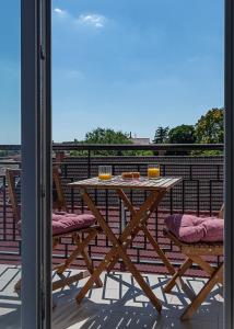 a wooden table and chairs on a balcony at Six Corners Mystic Corner City View Balcony Apartment in Pécs