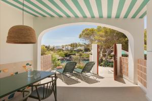 a dining room with a table and chairs and a patio at Inturotel Esmeralda Villas in Cala d´Or