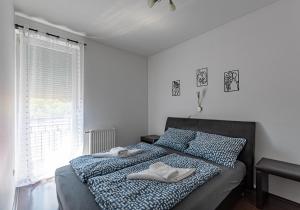 a bedroom with a bed with two towels on it at Six Corners Mystic Corner City View Balcony Apartment in Pécs