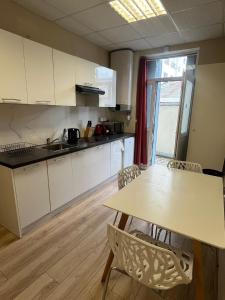 a kitchen with white cabinets and a table and chairs at Gentilly - Studio spacieux in Gentilly