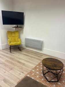 a living room with a yellow chair and a table at Gentilly - Studio spacieux in Gentilly