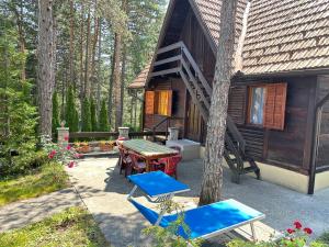 a cabin with a table and chairs and a tree at Apartment MK in Kaludjerske Bare