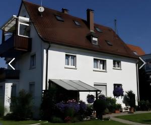 a large white building with a brown roof at Ferienwohnungen Michael u Christine in Langenargen