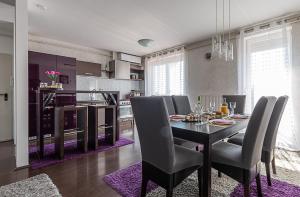 a dining room with a table and a kitchen at Six Corners Mystic Corner City View Balcony Apartment in Pécs