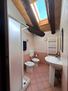 a bathroom with a sink and a toilet and a skylight at Mountain hut 'la Fraccia' in Trasquera